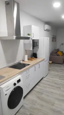 a kitchen with white cabinets and a stove top oven at Apto G2 SANLUCAR DE BARRAMEDA in Sanlúcar de Barrameda