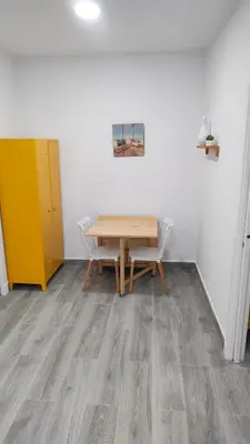 a dining room with a wooden table and chairs at Apto G2 SANLUCAR DE BARRAMEDA in Sanlúcar de Barrameda