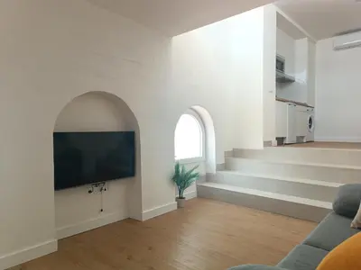 a living room with a flat screen tv on a wall at El Sueño in Jerez de la Frontera