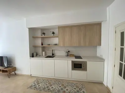 a white kitchen with a sink and a microwave at Apartamentos Tartaneros 4 in Sanlúcar de Barrameda