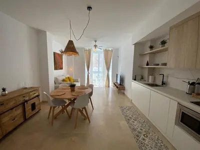 a kitchen with a table and chairs in a room at Apartamentos Tartaneros 4 in Sanlúcar de Barrameda