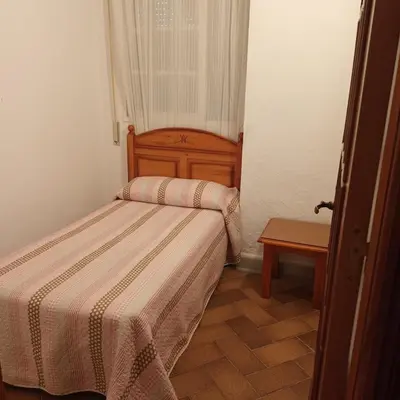 a small room with two beds and a table at Casa Rural MATEOS in El Puerto de Santa María