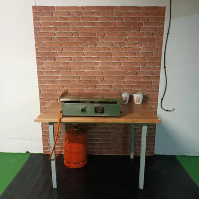 a small table with a brick wall and a stove at Casa Rural MATEOS in El Puerto de Santa María