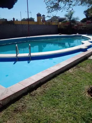 a swimming pool with blue water in a yard at Casa Rural MATEOS in El Puerto de Santa María