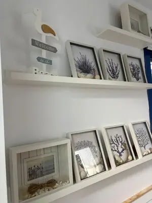 a shelf with framed pictures on it at Mi refugio azul in Cádiz