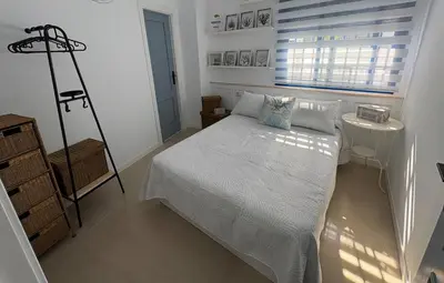 a bedroom with a white bed and a window at Mi refugio azul in Cádiz