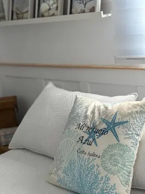 a pillow with a starfish on it sitting on a bed at Mi refugio azul in Cádiz