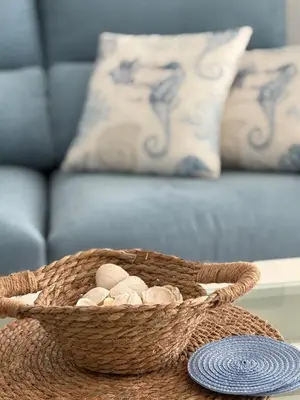 a basket of rocks on a table with a couch at Mi refugio azul in Cádiz