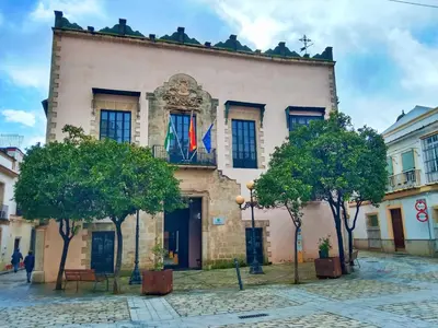 an old building with two flags on it at Apartamento Fuente de Los Naranjos in Jerez de la Frontera