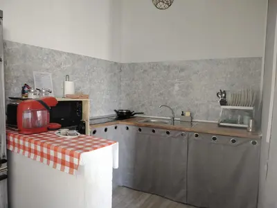 a kitchen with a sink and a counter with a table at Casa adosada con patio in Jerez