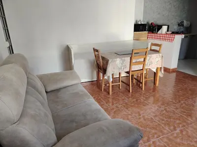 a living room with a couch and a table and chairs at Casa adosada con patio in Jerez