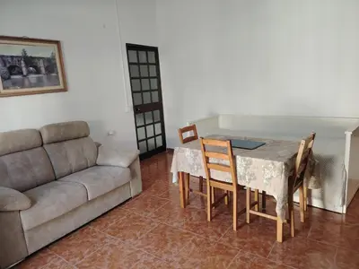 a living room with a couch and a table and chairs at Casa adosada con patio in Jerez