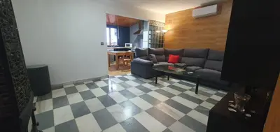 a living room with a couch and a checkered floor at Amplio apart con Wifi y Aire Acondicionado a 500 m de la playa La Barrosa in Chiclana de la Frontera