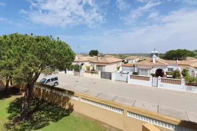 a white van parked on a road in front of a house at Amplio apart con Wifi y Aire Acondicionado a 500 m de la playa La Barrosa in Chiclana de la Frontera