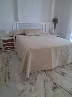 a bedroom with a large bed and two night stands at La caracola in Novo Sancti Petri