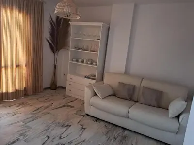 a living room with a couch and a book shelf at La caracola in Novo Sancti Petri