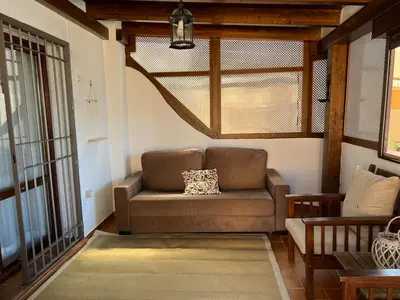 a brown couch in a living room with a window at La caracola in Novo Sancti Petri
