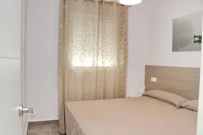 a small bedroom with a bed and a window at Apartamento Canario III in Conil de la Frontera