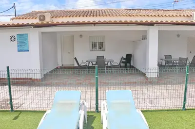 two lounge chairs in front of a house at Apartamento Canario III in Conil de la Frontera