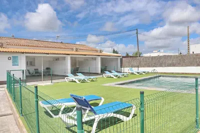 a fence with chairs and a pool in a yard at Apartamento Canario III in Conil de la Frontera