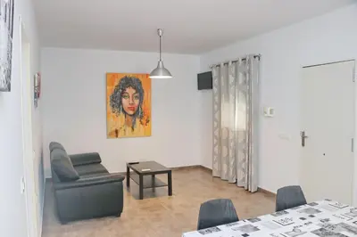 a living room with a chair and a table at Apartamento Canario III in Conil de la Frontera