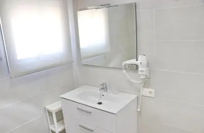 a white bathroom with a sink and a mirror at Chalet Ruperto III in Conil de la Frontera