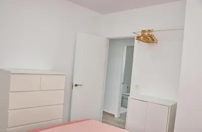a white bedroom with a bed and a mirror at Chalet Ruperto III in Conil de la Frontera