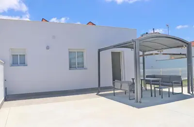 a table and chairs under a pavilion on a white building at Chalet Ruperto III in Conil de la Frontera