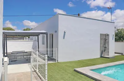 a white house with a swimming pool next to it at Chalet Ruperto III in Conil de la Frontera