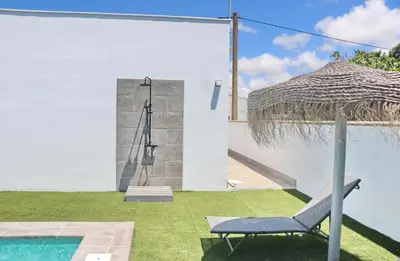 a blue chair sitting next to a swimming pool at Chalet Ruperto III in Conil de la Frontera
