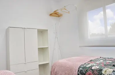 a white bedroom with a bed and a window at Chalet Ruperto III in Conil de la Frontera