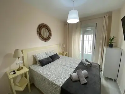 a bedroom with a bed and a mirror on the wall at Casa Lotte, centro histórico,AC, garaje, wifi in Sanlúcar de Barrameda