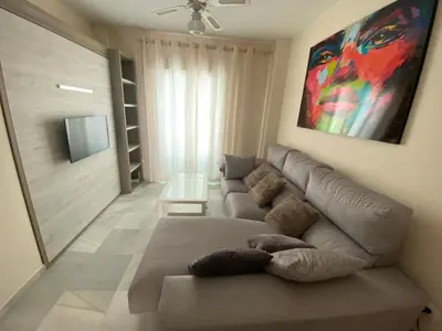 a living room with a couch and a tv at Casa Lotte, centro histórico,AC, garaje, wifi in Sanlúcar de Barrameda