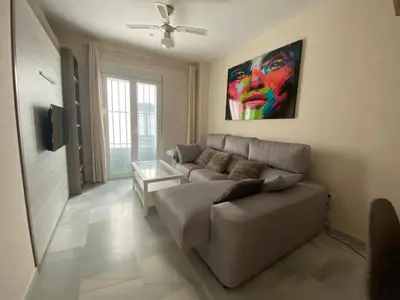 a living room with a couch and a painting on the wall at Casa Lotte, centro histórico,AC, garaje, wifi in Sanlúcar de Barrameda