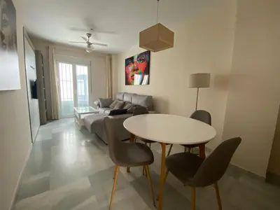 a living room with a table and a couch at Casa Lotte, centro histórico,AC, garaje, wifi in Sanlúcar de Barrameda