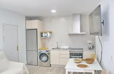 a small kitchen with a washer and dryer at Chalet Ruperto II in Conil de la Frontera