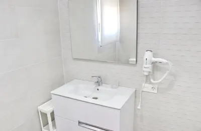 a white bathroom with a sink and a mirror at Chalet Ruperto II in Conil de la Frontera
