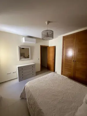 a bedroom with a bed and a dresser and a mirror at Apartamento turístico in Chiclana de la Frontera