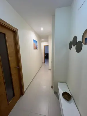 a hallway with a door and a white tile floor at Apartamento turístico in Chiclana de la Frontera