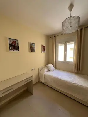 a bedroom with two beds and a window at Apartamento turístico in Chiclana de la Frontera