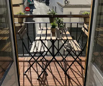 a table on a balcony with a view of a street at Apartamento turístico in Chiclana de la Frontera