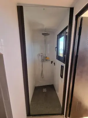 a bathroom with a shower with a glass door at Apartamento de lujo en Playa de Regla in Chipiona
