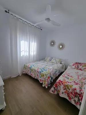 a bedroom with two beds and a window at Apartamento de lujo en Playa de Regla in Chipiona
