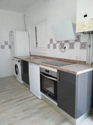 a kitchen with a stove top oven next to a dishwasher at Apartamento de lujo en Playa de Regla in Chipiona