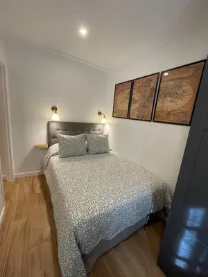 a bedroom with a bed and two lamps on the wall at Apartamento el Ancla in El Puerto de Santa María