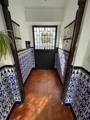 a hallway with blue and white tiles and a door at Apartamento el Ancla in El Puerto de Santa María