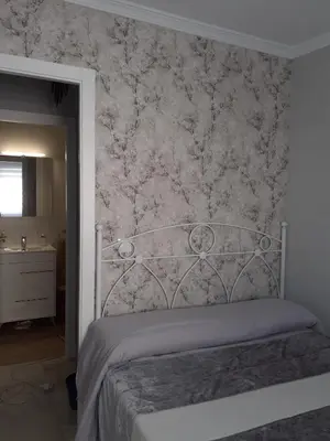 a bedroom with a bed with a floral wallpaper at Cruz Del MAR in Chipiona