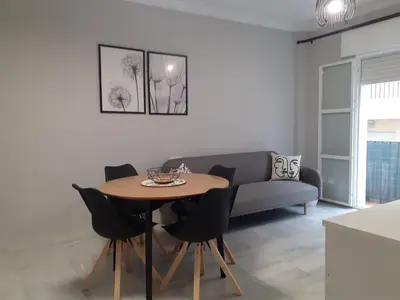 a living room with a table and a couch at Cruz Del MAR in Chipiona