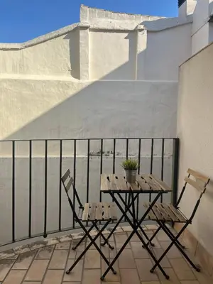 a patio table and two chairs on a balcony at Apartamento Edificio Carruaje in Jerez de la Frontera