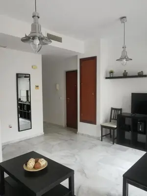 a living room with a table and a mirror at Apartamento Edificio Carruaje in Jerez de la Frontera